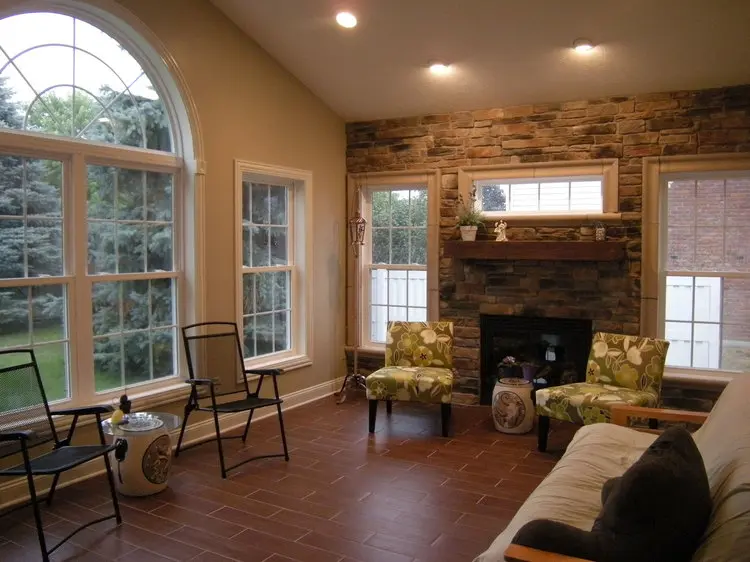 Custom-built sunroom interior with stone fireplace by L.V.C. Contractors